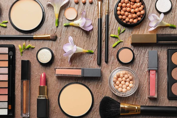 Många olika makeup produkter och vårblommor på färg bakgrund, Flat Lay — Stockfoto