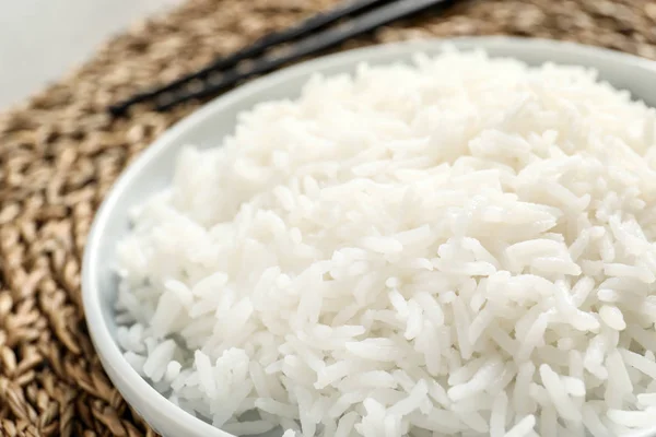 Prato de arroz cozido saboroso no tapete de vime, close-up — Fotografia de Stock