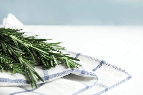 Frischer grüner Rosmarin und Serviette auf dem Tisch. Raum für Text — Stockfoto