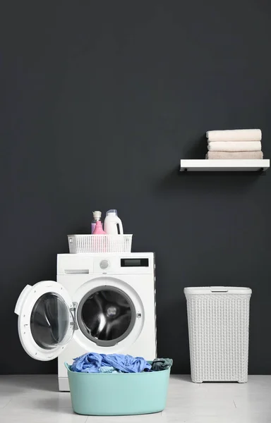 Современная стиральная машина, корзина для белья и полка с полотенцами в ванной комнате. Пространство для текста — стоковое фото