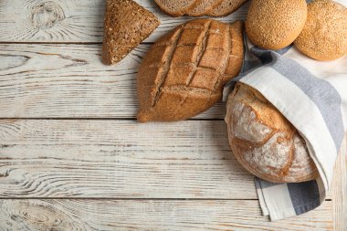 Tahta masanın üzerinde farklı taze ekmek türleri, düz yatıyordu. Metin için boşluk