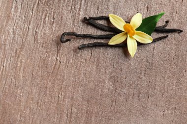 Kahverengi arka plan üzerinde vanilya çubukları ve çiçek ile Düz yatıyordu kompozisyon. Metin için alan