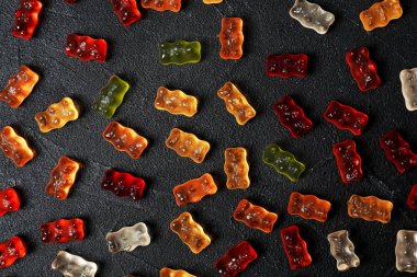 Siyah masa üzerinde lezzetli renk jöle ayılar ile Düz yatıyordu kompozisyon