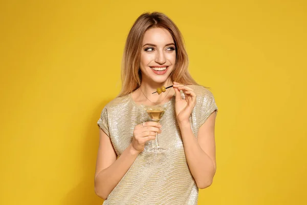 Mooie jonge vrouw met glas Martini cocktail op kleur achtergrond — Stockfoto