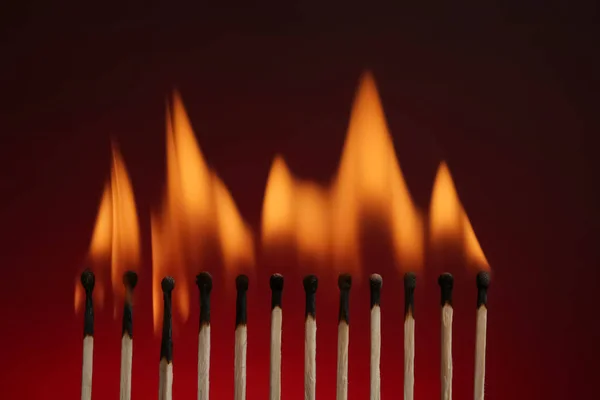 Line of burning matches on color background — Stock Photo, Image