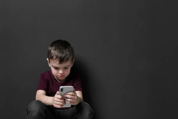 Szomorú kisfiú-val mozgatható telefon-ra fekete háttér, hely részére szöveg — Stock Fotó