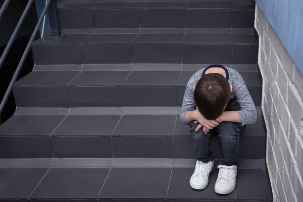 실내 계단에 앉아 슬픈 어린 소년 — 스톡 사진