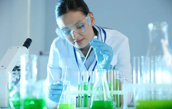Ženský vědec pracující se vzorkem v moderní chemické laboratoři — Stock fotografie