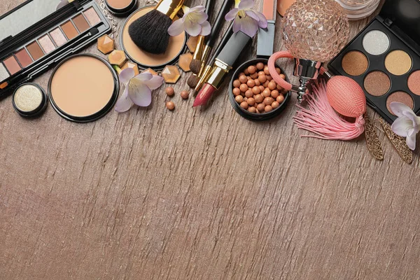 Veel verschillende make-up producten en lente bloemen op kleur achtergrond, platte lay. Ruimte voor tekst — Stockfoto
