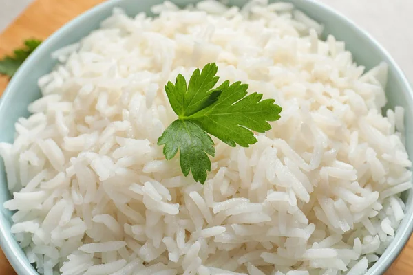 Cuenco de arroz delicioso con perejil en la mesa, primer plano —  Fotos de Stock