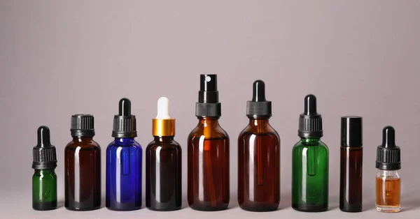 Kosmetické láhve základních olejů na barevném pozadí — Stock fotografie