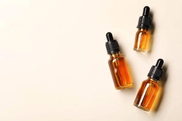 Cosmetische flessen etherische oliën en ruimte voor tekst op kleur achtergrond, platte lay — Stockfoto