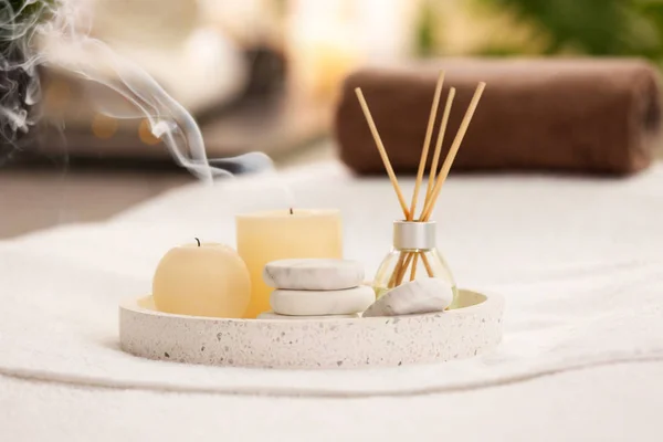 Složení s osvěžovač vzduchu, svíčky a kameny na masážním stolku v lázeňském salonu — Stock fotografie