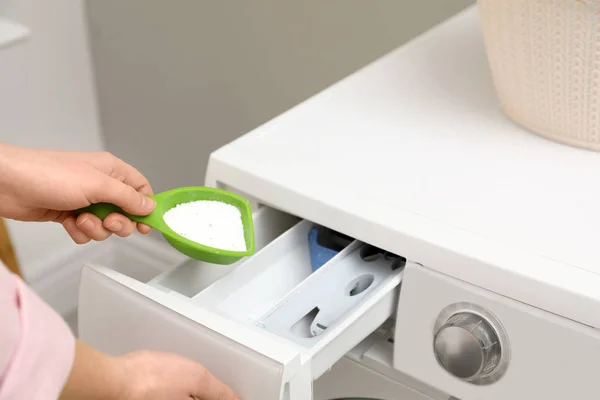 Kvinna hälla pulver i lådan med tvättmaskin i tvättstugan, närbild — Stockfoto