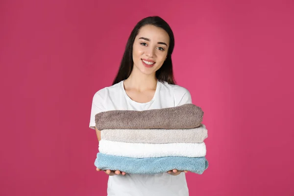 Mutlu genç kadın renkli arka planda temiz havlu tutan. Çamaşır günü — Stok fotoğraf