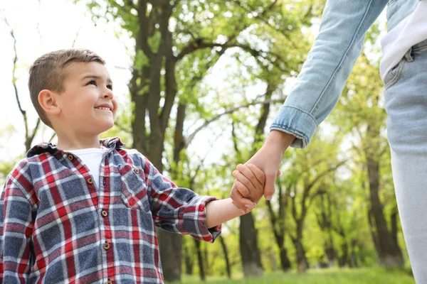 Roztomilé malé dítě se drží za ruce s matkou venku, s nízkým výhledem. Rodinný víkend — Stock fotografie