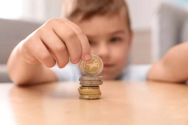 Mignon petit garçon empilant des pièces de monnaie à la maison, se concentrer sur la main — Photo