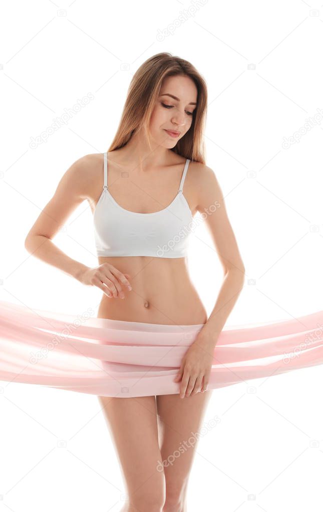Young slim woman covering her body with fabric on white background