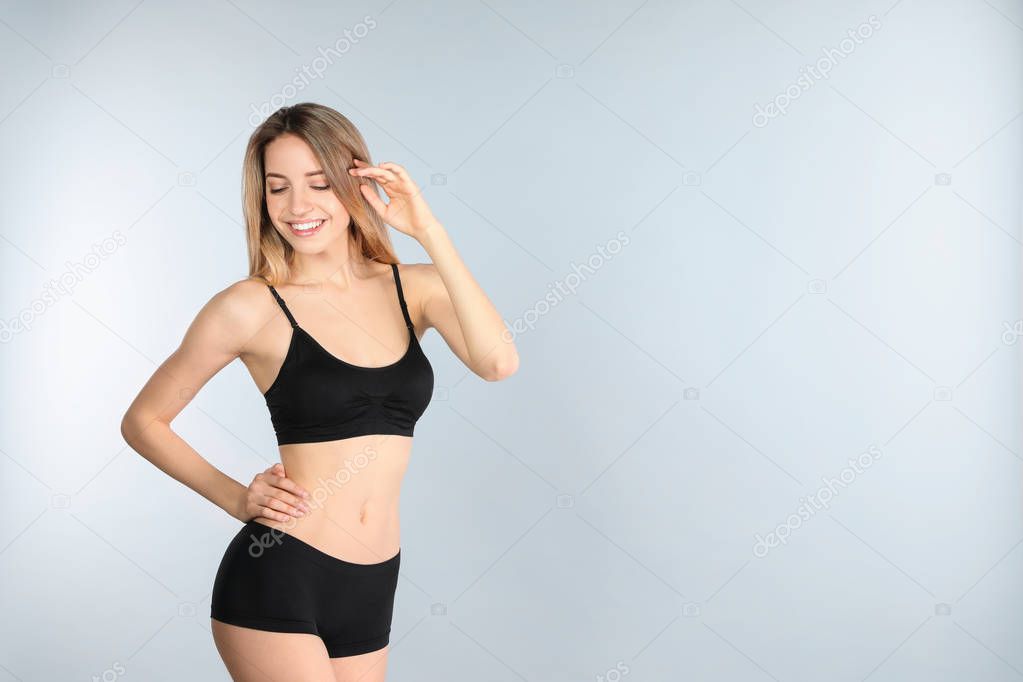 Young slim woman on light background, space for text. Perfect body