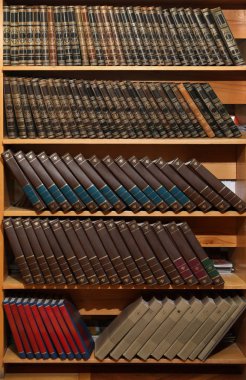 Kütüphanede kitap koleksiyonu olan tahta dolaplar.