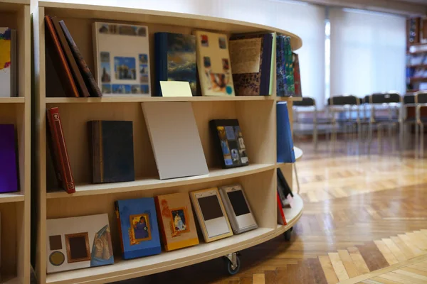 Coleção de livros em stand de exibição na biblioteca, espaço para texto — Fotografia de Stock