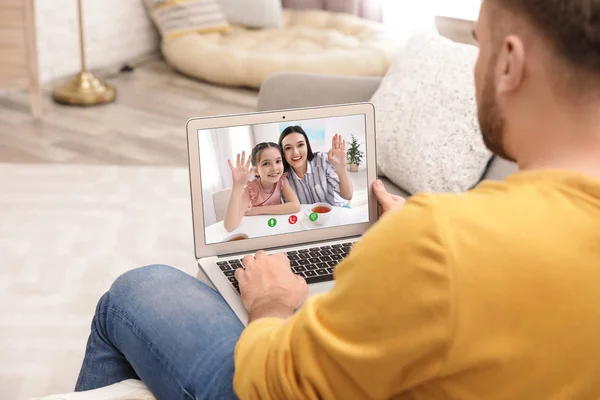 Closeup view of man talking with family members via video chat at home