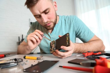 Atölyede masada cep telefonu tamir teknisyeni, closeup