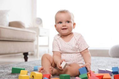 Sevimli kız bebek odada yapı taşları ile oynarken