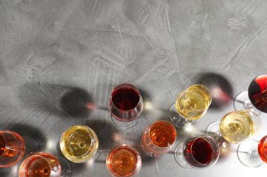 Gri arka plan üzerinde şarap ile farklı bardak, düz yatıyordu. metin için alan
