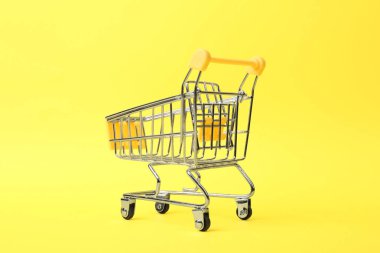Renkli arka planda saplı boş alışveriş arabası