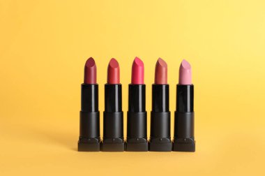 Renkli arka planda farklı rujlar. Makyaj kozmetik ürün