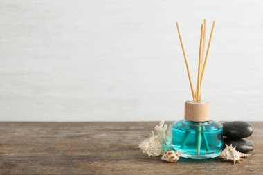 Aromatik sazlık sprey, spa taşları ve hafif arka plan karşı ahşap masa üzerinde deniz kabukları. Metin için alan