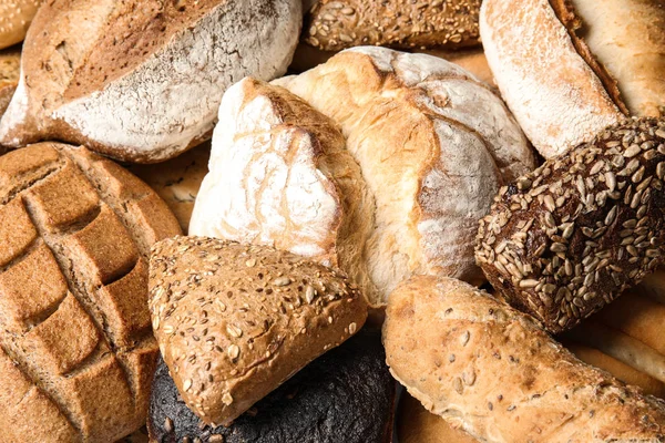 Diferentes tipos de pan fresco como fondo, primer plano — Foto de Stock