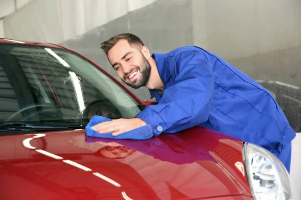 Trabalhador de limpeza capô de automóvel com pano na lavagem de carro — Fotografia de Stock