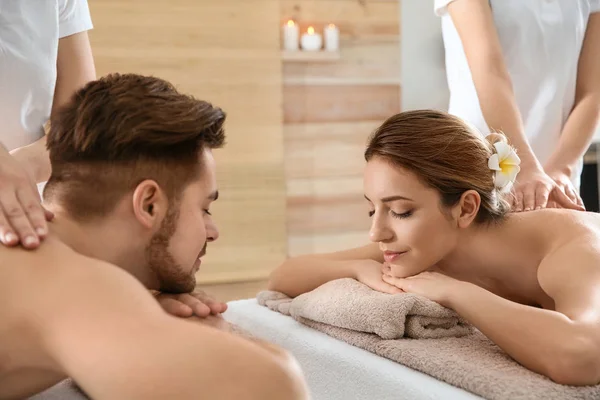Romántica pareja joven disfrutando de masaje de espalda en el salón de spa —  Fotos de Stock