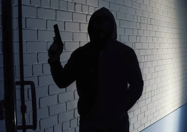 Silhuett av mannen med pistol i hoodie inomhus. Farliga kriminella — Stockfoto
