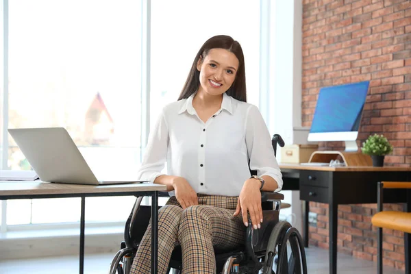 Portret młodej kobiety na wózku inwalidzkim w miejscu pracy — Zdjęcie stockowe