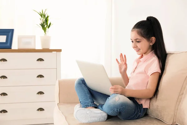 Malá holčička používající videokonverzaci na přenosném počítači doma — Stock fotografie