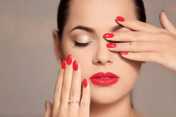 Belle jeune femme avec une manucure lumineuse sur fond de couleur, gros plan. Tendances du vernis à ongles — Photo