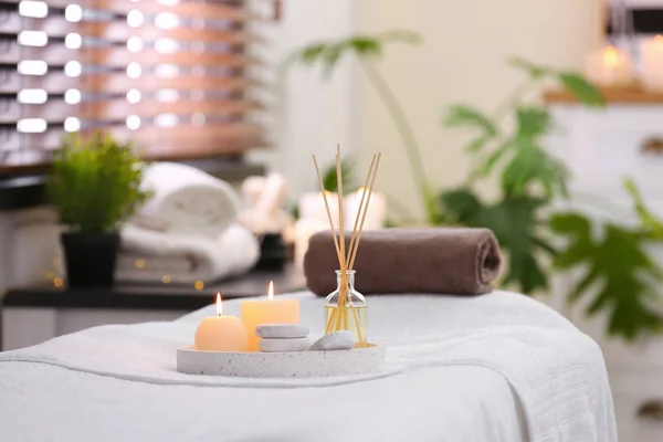 Composition avec désodorisant roseau, bougies et pierres sur table de massage dans le salon de spa — Photo