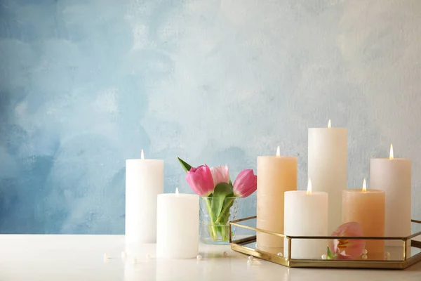 Σύνθεση με καύση κεριά στο τραπέζι με φόντο χρώμα. Χώρος για κείμενο — Φωτογραφία Αρχείου
