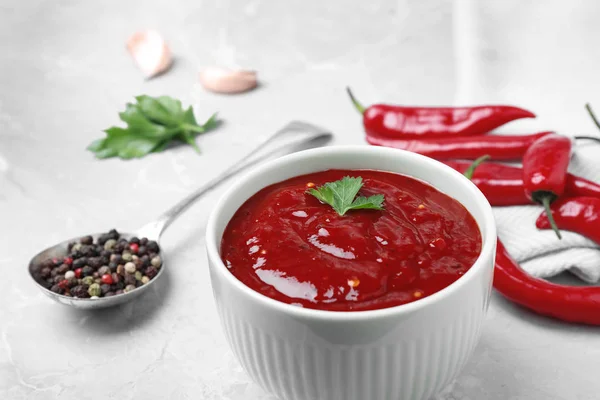 Bowl of hot chili sauce and ingredients on table — Stock Photo, Image