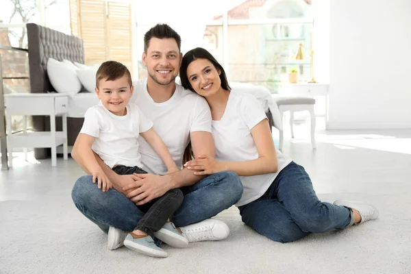 Gelukkige ouders en hun zoon zitten samen op de vloer thuis. Family time — Stockfoto