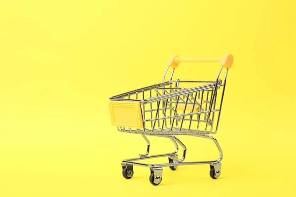 Carro de compras vacío sobre fondo de color. Espacio para texto — Foto de Stock