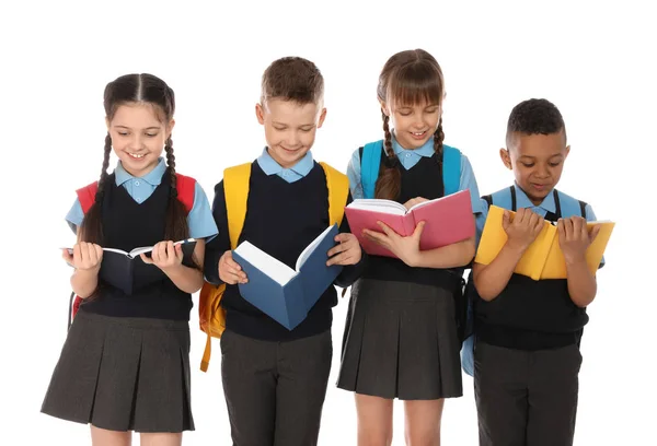 Retrato de niños lindos en uniforme escolar con libros sobre fondo blanco —  Fotos de Stock