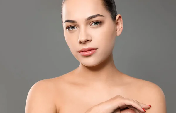 Portrait de jeune femme avec beau visage et maquillage naturel sur fond de couleur — Photo