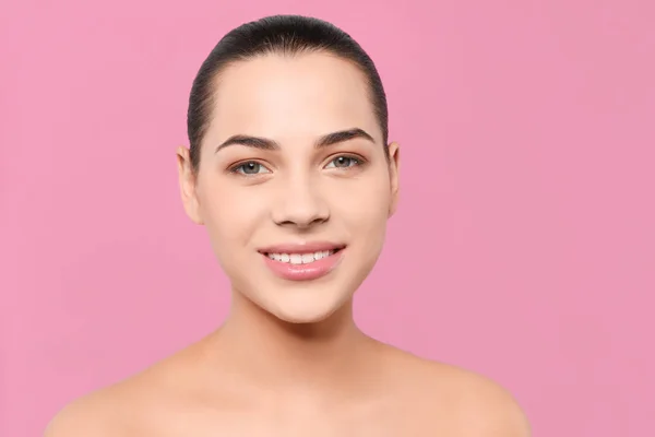 Portret van jonge vrouw met mooi gezicht en natuurlijke make-up op kleur achtergrond — Stockfoto