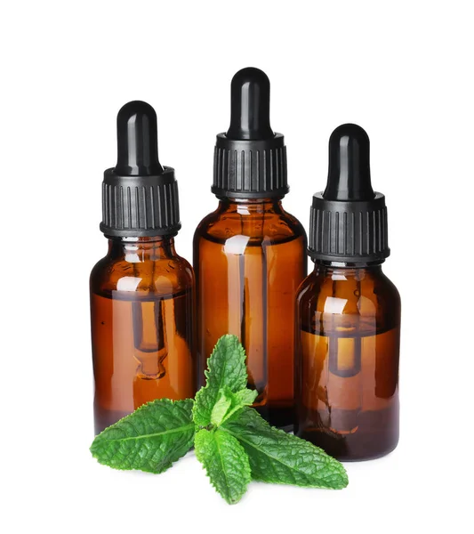 Different bottles of essential oils and mint on white background — Stock Photo, Image