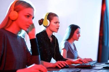 Gençler kapalı bilgisayarlarda video oyunları oynuyorlar. Esports turnuvası