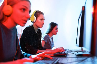 Gençler kapalı bilgisayarlarda video oyunları oynuyorlar. Esports turnuvası